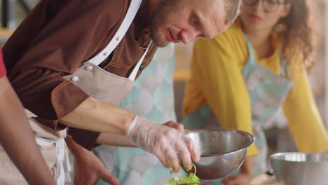 chef serving salad on plate during cooking master class