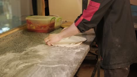 man cooking pizza in the kitchen of restaurant