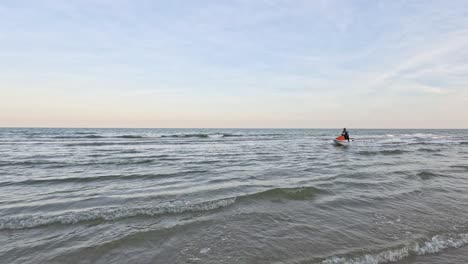 kayakista en solitario remando a través de las aguas tranquilas del mar
