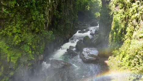 Imágenes-Aéreas-Volando-A-Través-De-La-Niebla-De-Una-Cascada-Sobre-Un-Exuberante-Barranco-Verde-Atmosférico