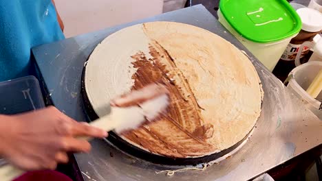 apply different flavors to freshly cooked crepe, close up