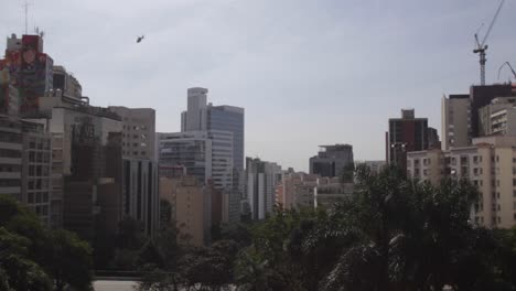 helicopter flying over a bustling city skyline