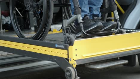 a man in a wheelchair on a lift of a vehicle for people with disabilities. lifting equipment for people with disabilities - man in wheelchair near the vehicle