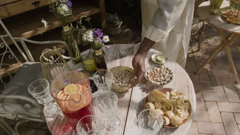 person serving snacks and drinks on an outdoor table