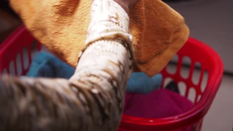 person putting towels into a laundry basket