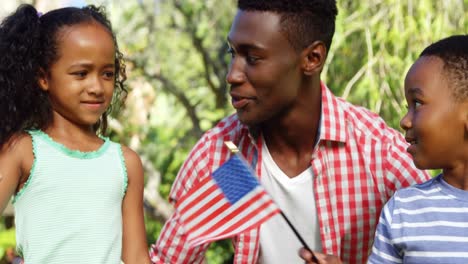 a boy and a girl holding an american flag and a young arriving to embrace them