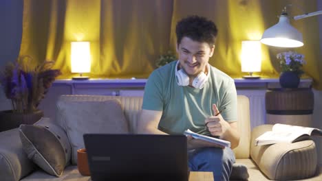 Successful-student-looks-at-the-camera-with-a-smile-while-studying-at-home.