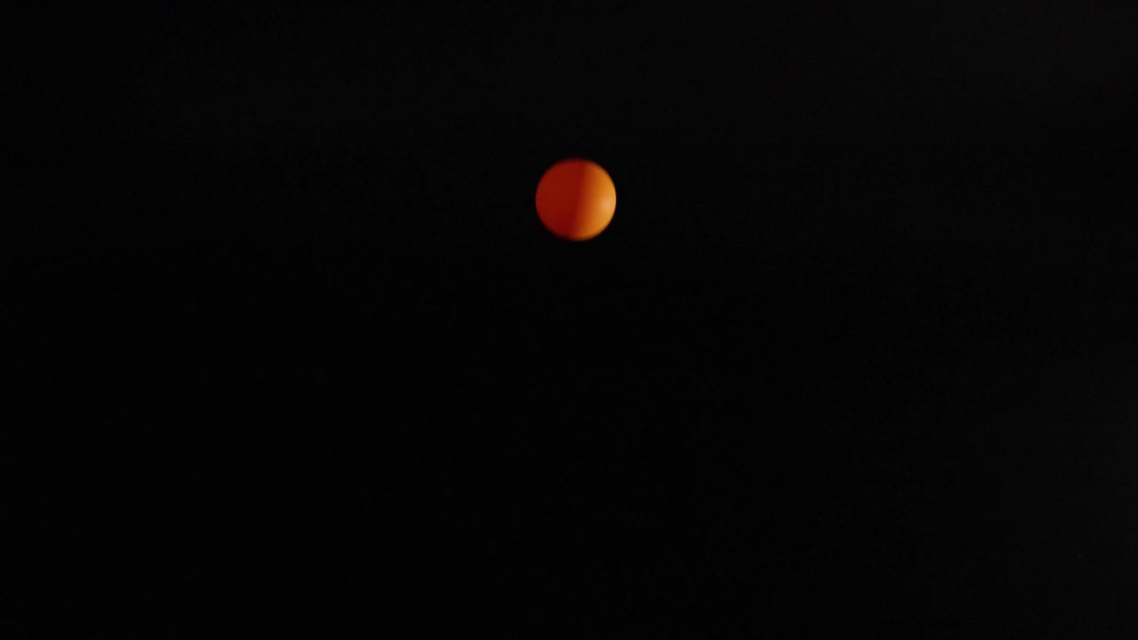 Orange ball bouncing against a dark background