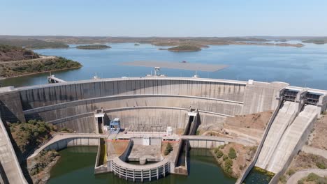 a car traveling along the road on top of the giant concrete dam walls