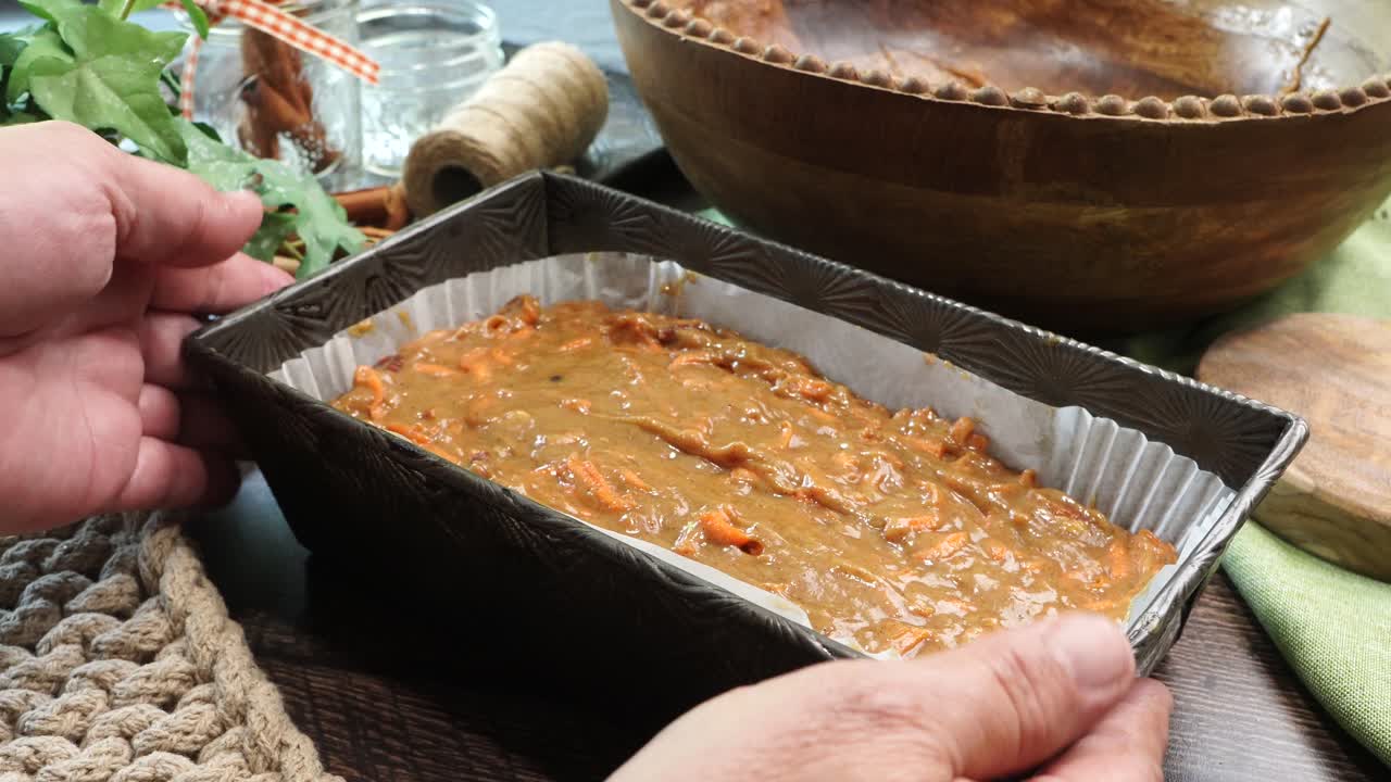 Baking a carrot cake loaf with cream cheese icing and topped with roasted salted pecans. Making a Autumn dessert with carrots, flour, sugar, nuts and frosting with a top down view that' close up.