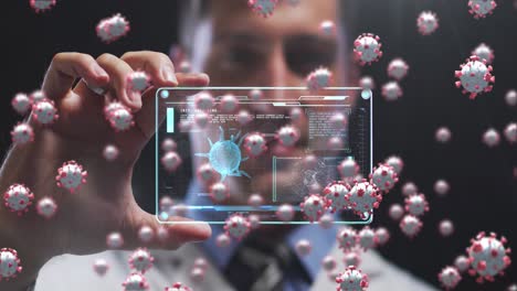 animation of covid 19 cells over man holding screen with covid 19 cell and medical data processing