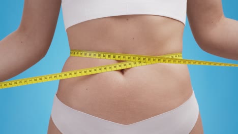 woman measuring waist with tape measure