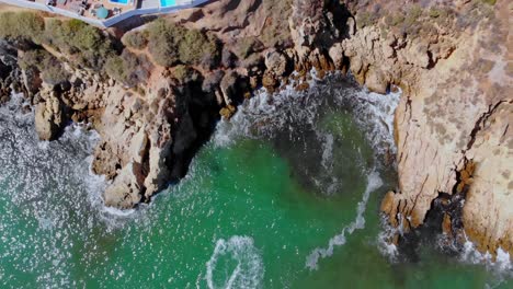 Drone-shot-of-the-water-by-the-rock-down-the-coast