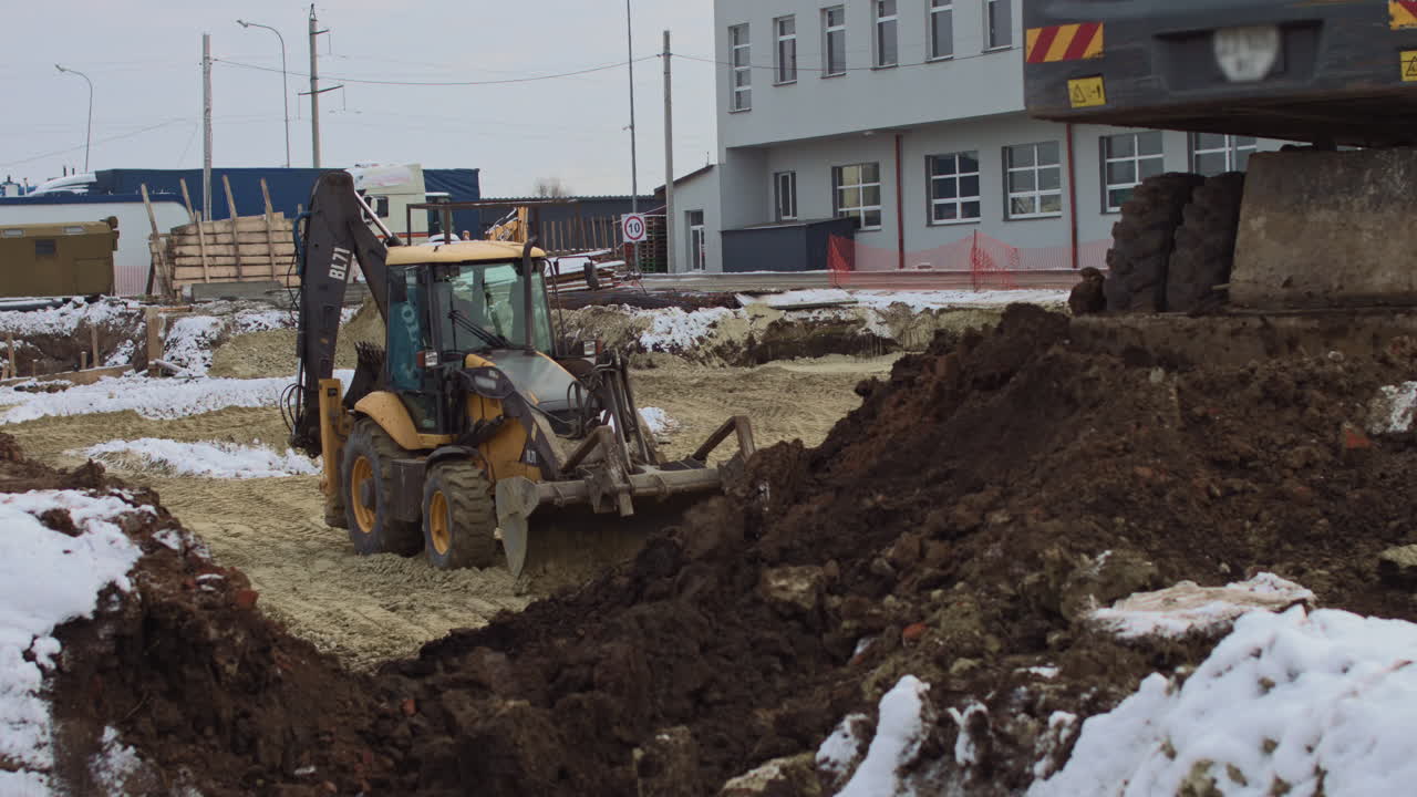 Construction Site with Excavator and Snow