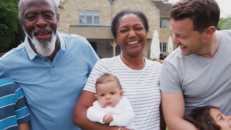 Portrait-Of-Smiling-Multi-Generation-Mixed-Race-Family-In-Garden-At-Home