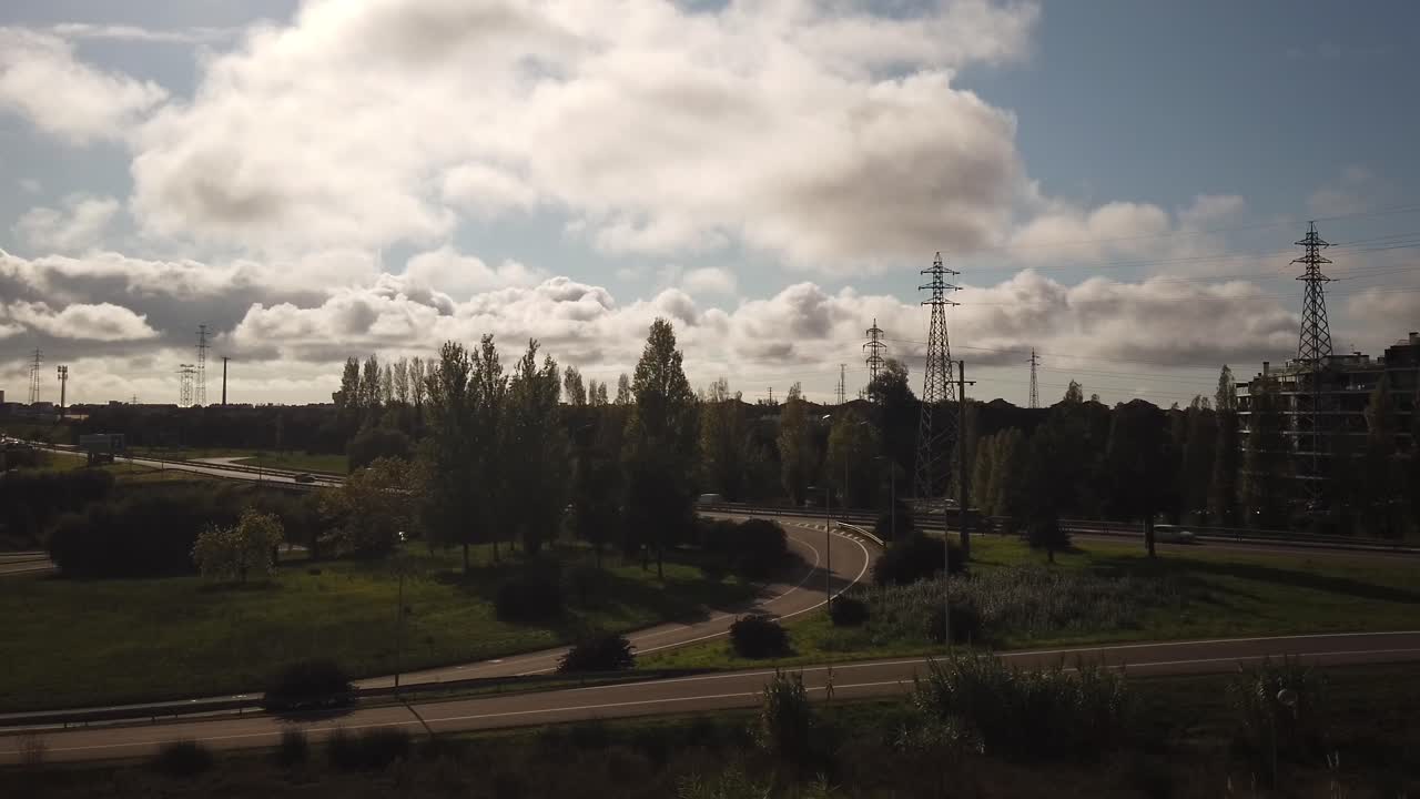 timelapse con la conducción de automóviles en una carretera con postes eléctricos y cielo azul con nubes blancas