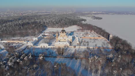 Aerial-view-of-the-Pazaislis-monastery-and-the-Church-of-the-Visitation-in-Kaunas,-Lithuania-in-winter,-snowy-landscape,-Italian-Baroque-architecture,-zooming-in,-crane-shot,-dolly-zoom