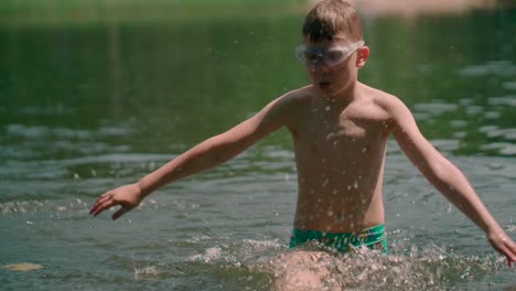 Niño-Con-Traje-De-Baño-En-El-Lago-Salpicando-Agua-Y-Caminando