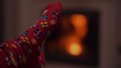 Mujer-Joven-Vistiendo-Calcetines-De-Lana-Caliente-Junto-A-La-Chimenea-En-La-Víspera-De-Navidad-2