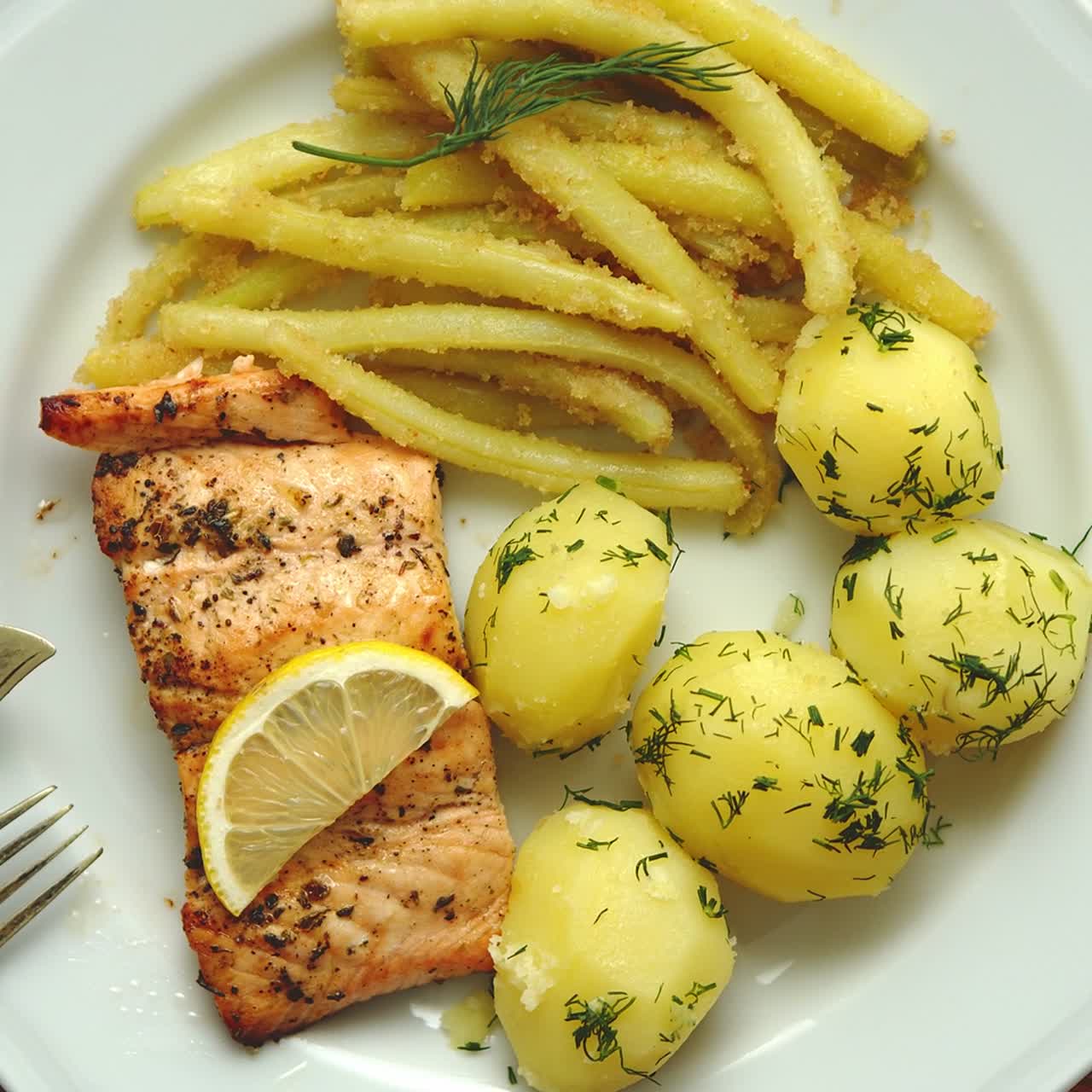 salmón fresco y sabroso al horno servido con patatas hervidas jóvenes y judías amarillas