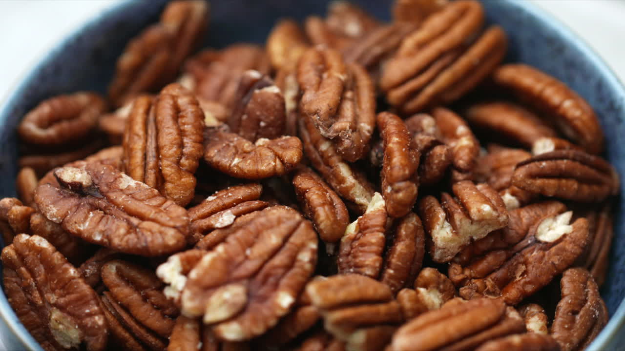 Pecan nuts rotating in blue bowl