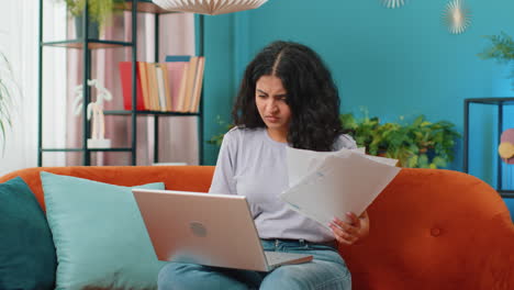 mujer india estresada mirando a la deuda bancaria no pagada préstamo, haciendo papeleo planificación del presupuesto lanza facturas