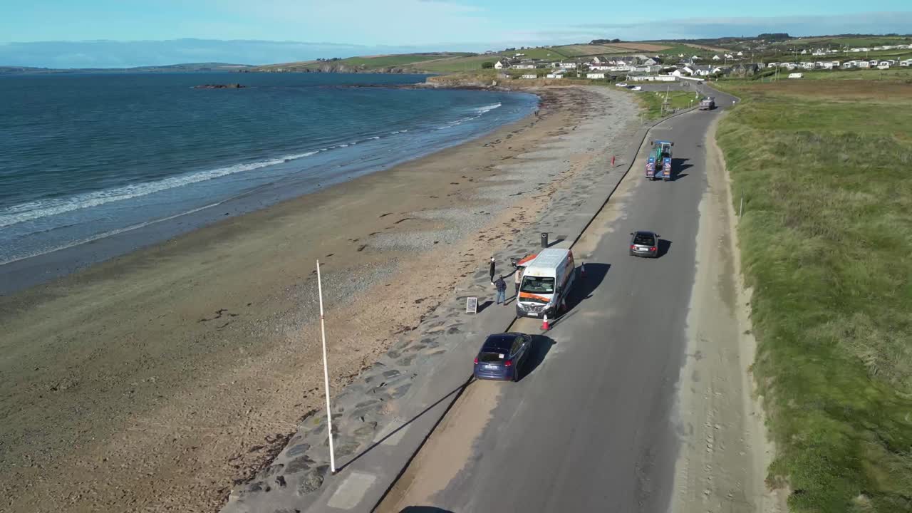 Aerial View of Coastal Road and Beach with Cars and People