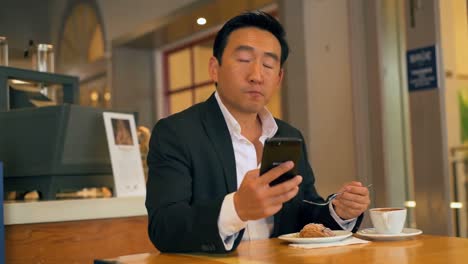 businessman having food while using mobile phone 4k