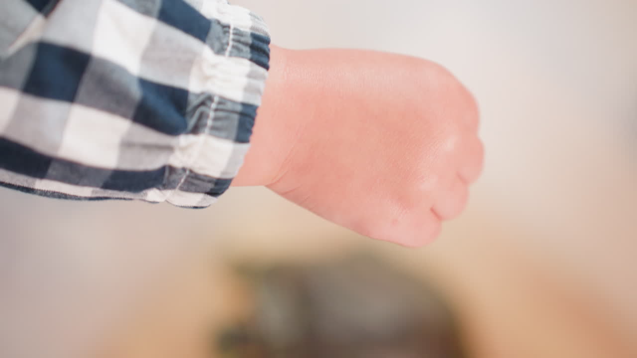 Close up of toddler holding small transparent bowl while feeding animal inside container, tiny hands carefully offering food during interactive learning activity