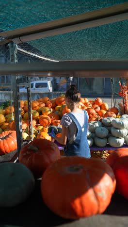 woman looking at pumpkins at a fall market