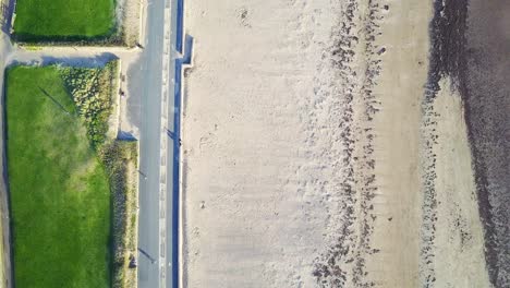 Vista-Aérea-A-Vista-De-Pájaro-De-La-Playa-De-Arena-Y-Hierba-Verde-En-Un-Día-Soleado