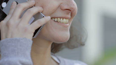 Cropped-shot-of-smiling-mature-brunette-talking-on-smartphone
