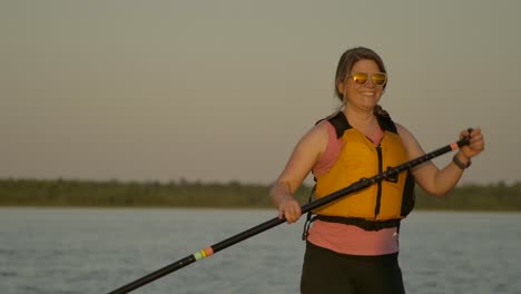 happy pretty girl paddle boarding closeup sunset smiling slomo