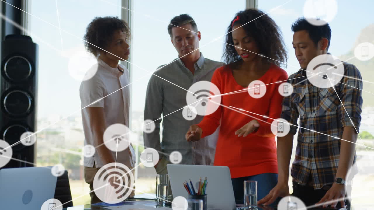Animation of network of digital icons over diverse colleagues discussing together at office