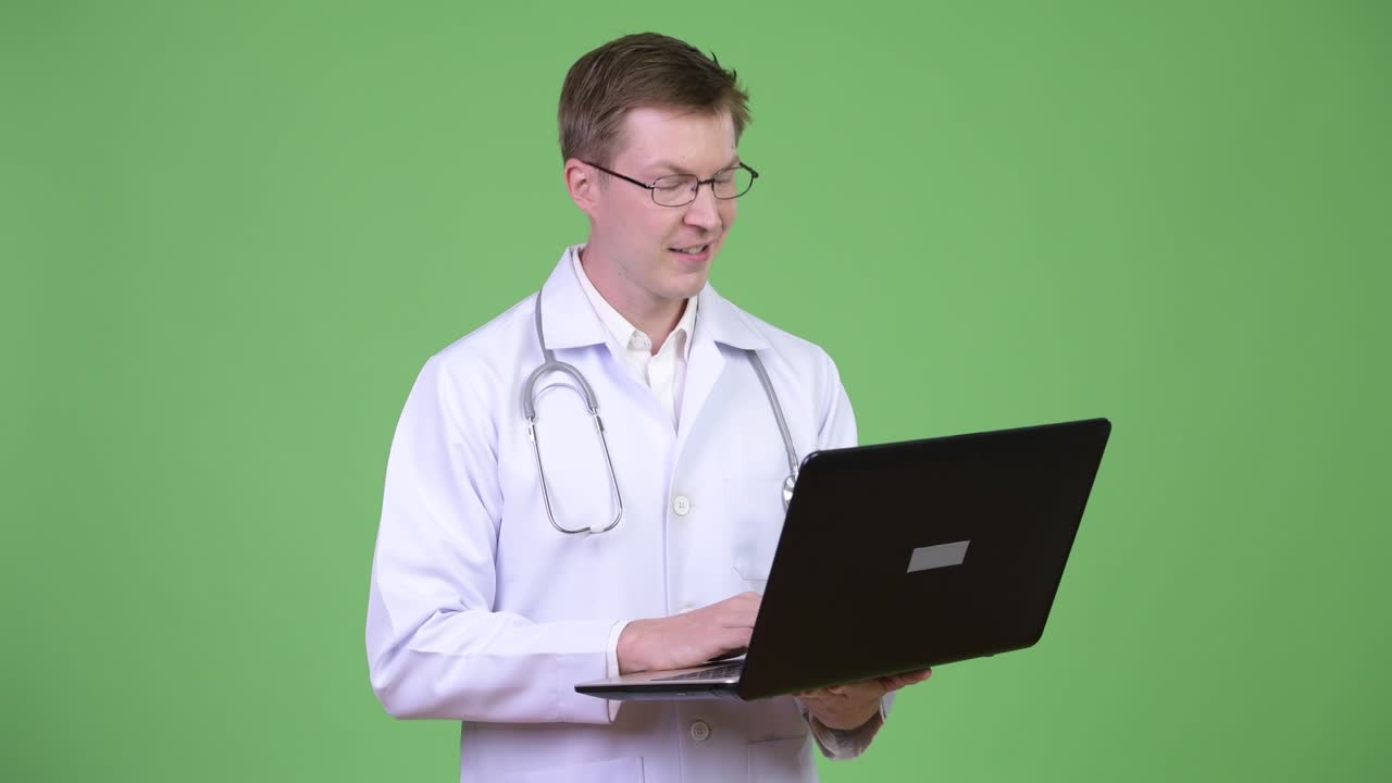 Portrait Of Young Man Doctor Using Laptop Computer
