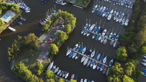 aerial tilt down of club náutico san isidro in buenos aires with anchored luxury sailboats