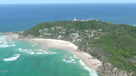 Vista-Aérea-De-Drones-De-La-Bahía-De-Byron-Rodeada-Por-Un-Día-De-Agua-Azul,-Incluido-El-Faro-De-La-Bahía-De-Byron