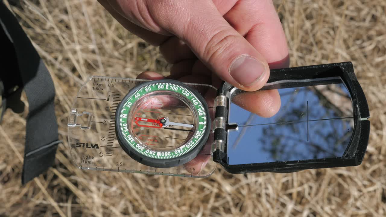 Person using a compass to navigate in the wild, Handheld
