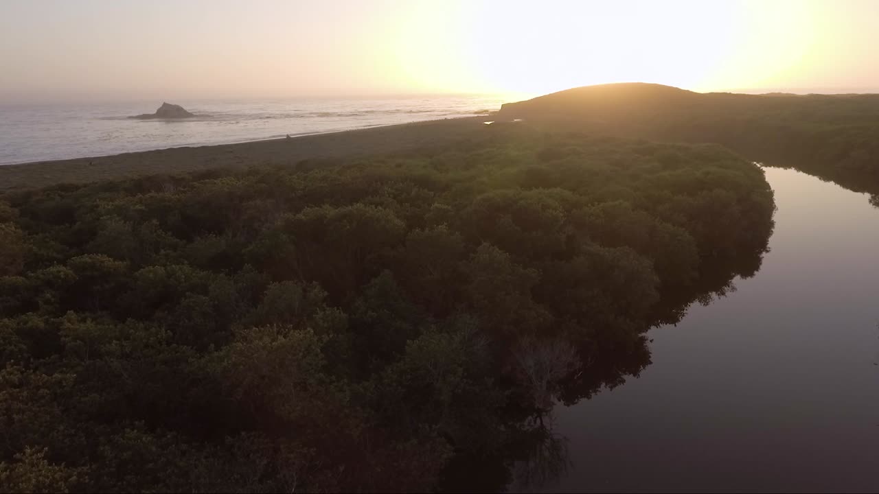 일몰 동안 해안에서 외로운 바위