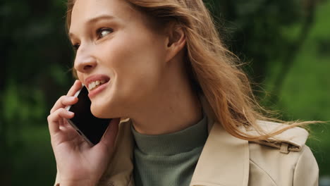 estudiante caucásica hablando por teléfono al aire libre.