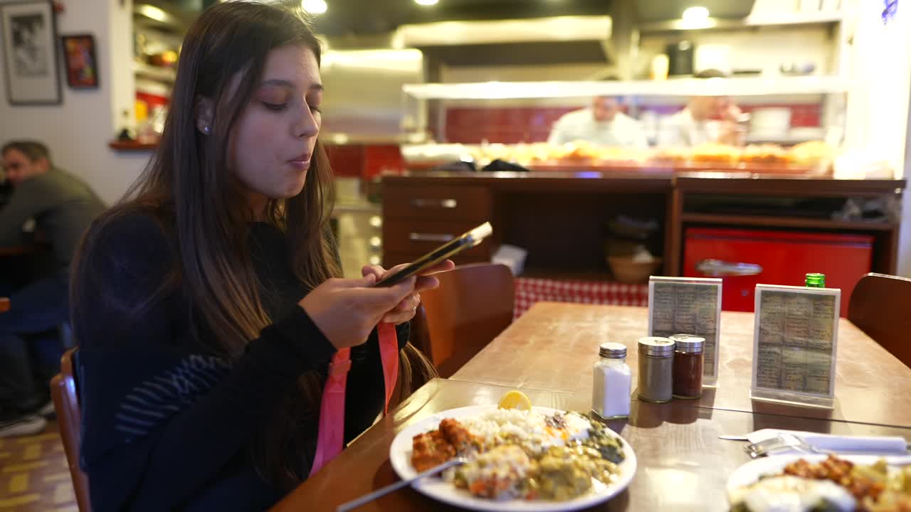 mujer tomando una foto de comida en un restaurante