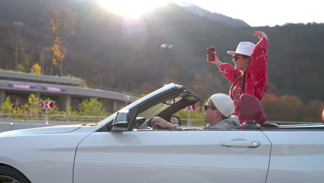 couple taking selfie in convertible car