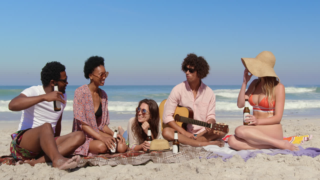 그룹 친구들이 해변에서 재미있게 4k를 즐기고 있습니다.