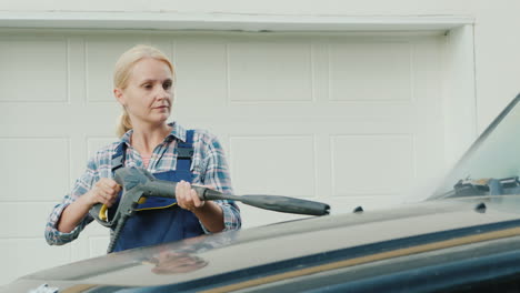 Porträt-Einer-Aktiven-Frau,-Die-Ihr-Auto-In-Der-Nähe-Der-Garage-Wäscht