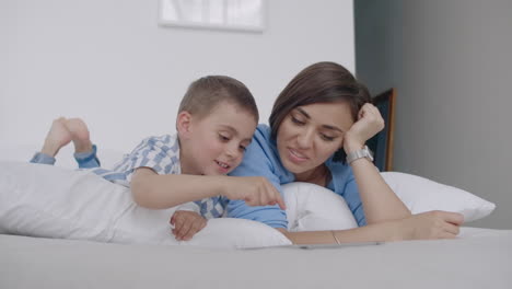 familia feliz madre y hijo con tableta por la noche. familia feliz madre e hijo con tabletas por la noche antes de acostarse