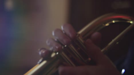 close up shot of fingers playing a trumpet in studio