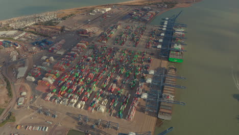 Toma-Aérea-En-Círculos-Altos-De-Contenedores-Que-Esperan-Ser-Cargados-En-El-Puerto-De-Felixstowe