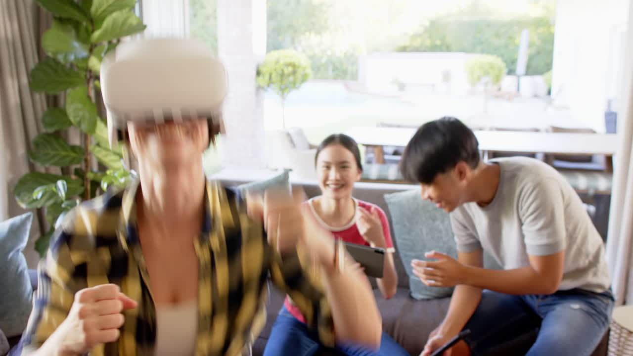 Using VR headset, woman enjoying virtual reality while family recording with smartphones