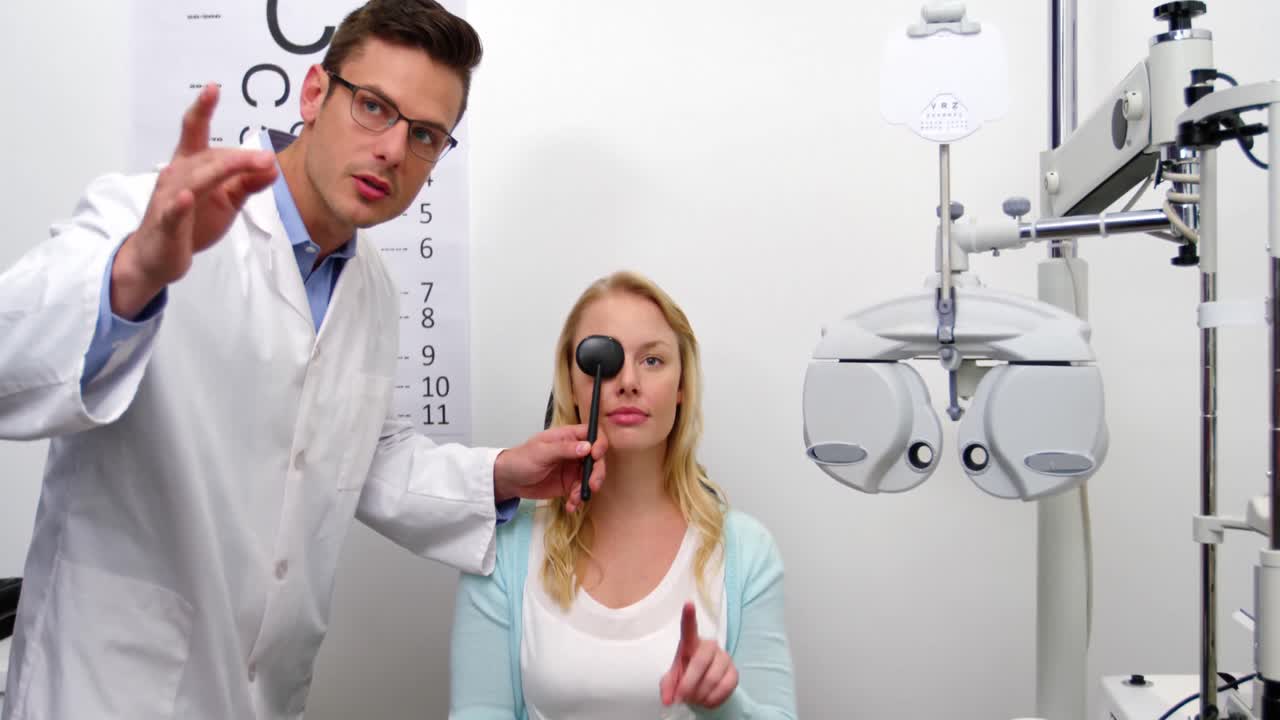 Optometrist examining female patient with medical equipment