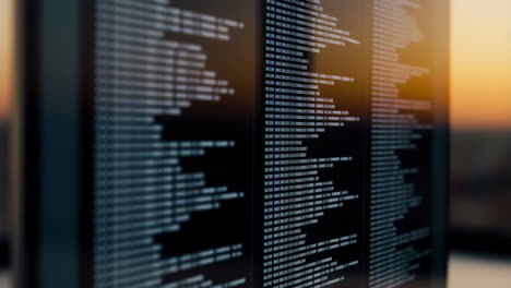 programming code on a monitor screen with a sunset backdrop